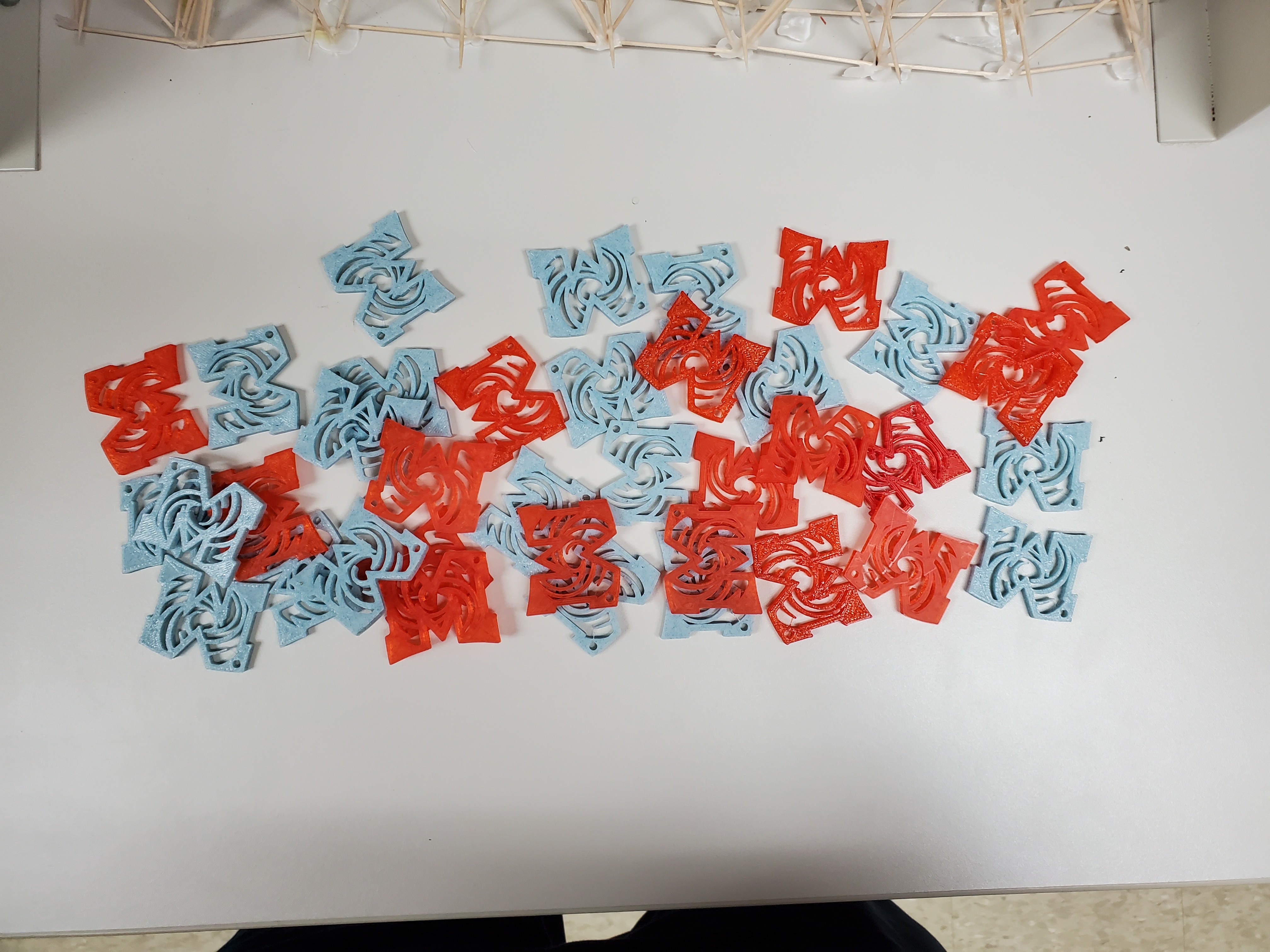 3D-printed keychains being printed at the founder's workbench